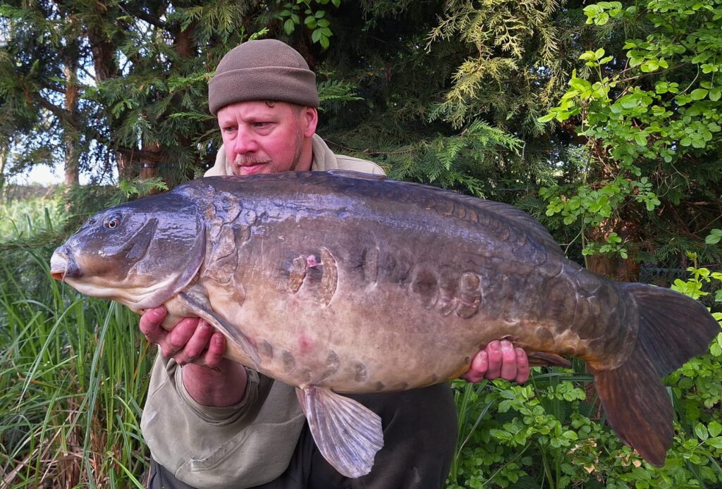 man holding the fish he caught at Pochard
