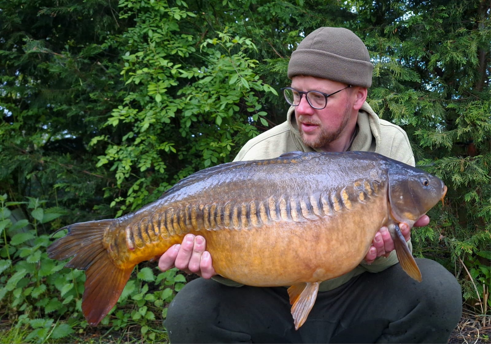 Man crouched down holding fish